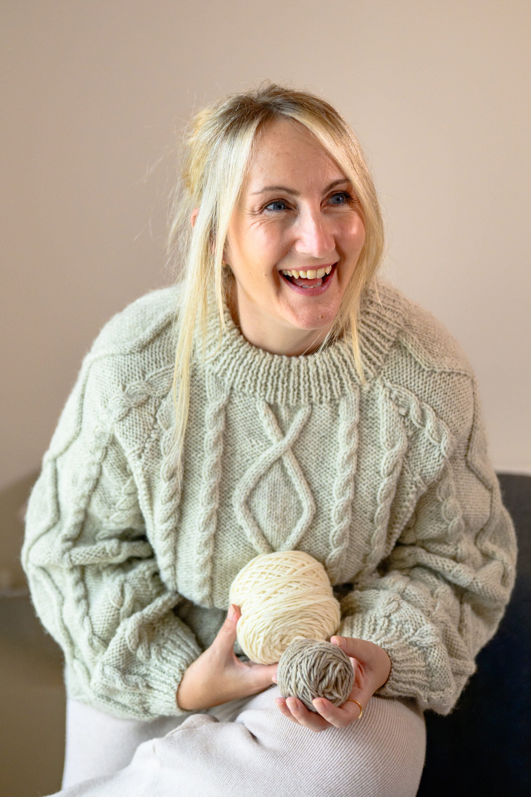 Louise laughing wearing an Aran sweater