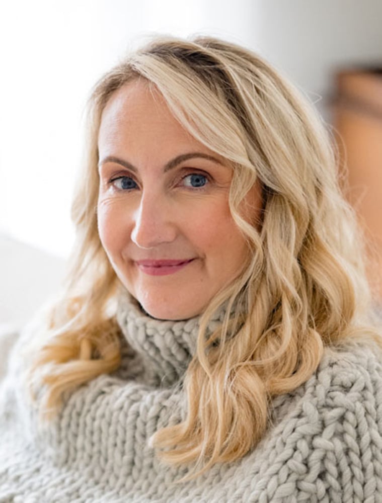 Louise smiling wearing a knitted sweater