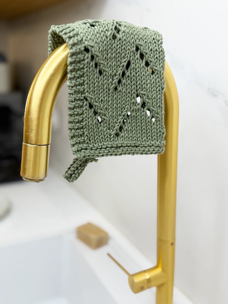 lace knit dishcloth hanging over faucet